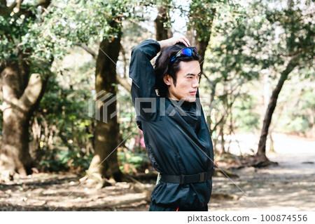 male runner stretching 100874556