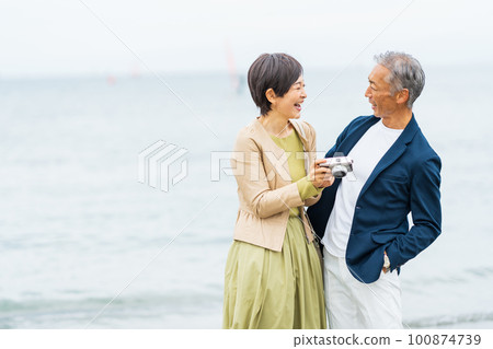 Senior couple walking along the beach Senior couple walking along the beach 100874739