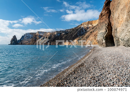 calm azure sea and volcanic rocky shores. Small waves on water surface in motion blur. Nature summer ocean sea beach background. Nobody. Holiday, vacation and travel concept calm azure sea and volcanic rocky shores. Small waves on water surface in motion blur. Nature summer ocean sea beach background. Nobody. Holiday, vacation and travel concept 100874971