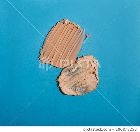 Different swatches of cosmetic products for the face and body on blue background. Texture of skin care cosmetic product. 100875258