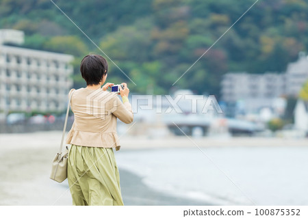 中年婦女在海邊拍照 100875352