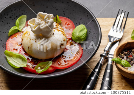 Burrata cheese, tomatoes and basil Burrata cheese, tomatoes and basil 100875511