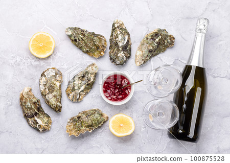 Fresh oysters with sauce and lemons 100875528