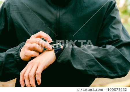 Male runner checking smart watch Male runner checking smart watch 100875662