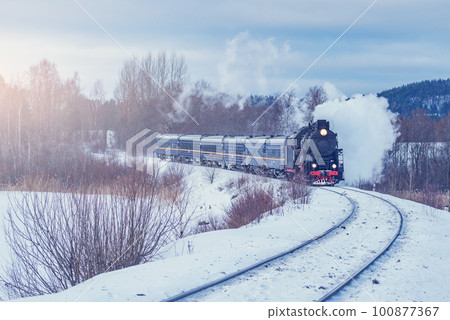 Retro steam train moves at winter morning time. 100877367