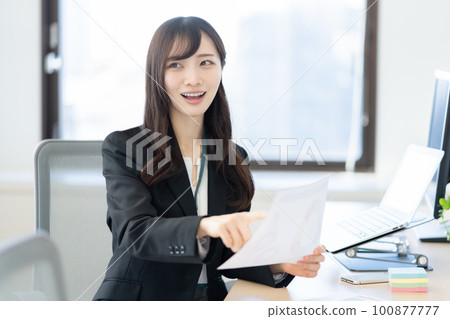 Businesswoman having a conversation while looking at documents in the office Businesswoman having a conversation while looking at documents in the office 100877777