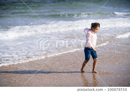 Cute little girl spending time next to the ocean Cute little girl spending time next to the ocean 100878550
