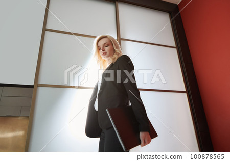 Young adult business woman wearing formalwear and carrying the laptop Young adult business woman wearing formalwear and carrying the laptop 100878565