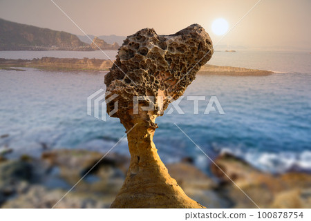 The sun is gradually moving towards sea level. Factory silhouette at sunset. 100878754