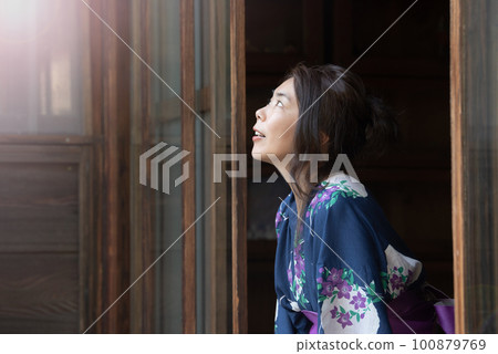 一個穿著浴衣的女人在夏天坐在門廊上仰望天空特寫 100879769