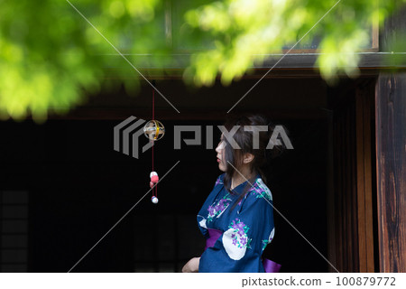 A woman in a yukata on the porch in summer with a wind chime A woman in a yukata on the porch in summer with a wind chime 100879772