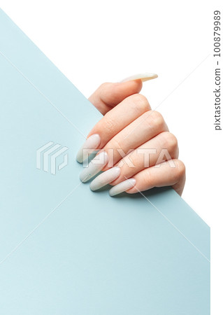 Manicured woman's hand holding blue paper. Manicured woman's hand holding blue paper. 100879989