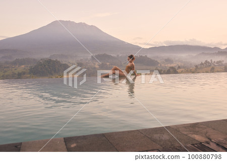 Woman Enjoying Luxury Resort Pool View of Bali Volcano Agung Woman Enjoying Luxury Resort Pool View of Bali Volcano Agung 100880798