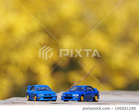 Scenery with miniature cars: two Imprezas with yellow autumn leaves in the background 100881299