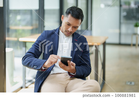 Portrait of a male business owner using a mobile phone. 100881981