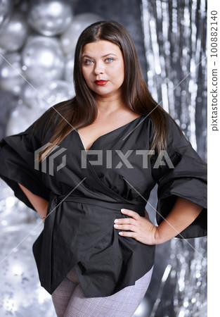 Serious plus size woman posing 100882140