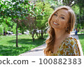 Happy blond woman relaxing in a public park 100882383