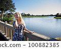 Smiling woman on the wooden bridge 100882385