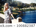 Smiling woman on the wooden bridge 100882387