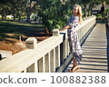 Smiling woman on the wooden bridge 100882388