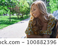 Happy blond woman relaxing in a public park 100882396