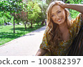 Happy blond woman relaxing in a public park 100882397