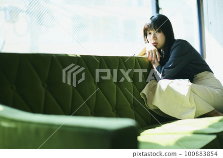Woman portrait sitting on sofa Woman portrait sitting on sofa 100883854