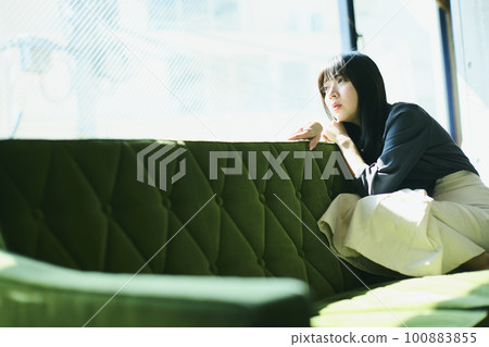 Woman portrait sitting on sofa Woman portrait sitting on sofa 100883855