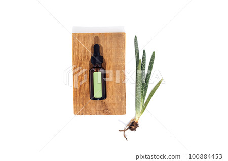Mockup of a cylindrical shape with green stiker lies on a wooden standes 100884453