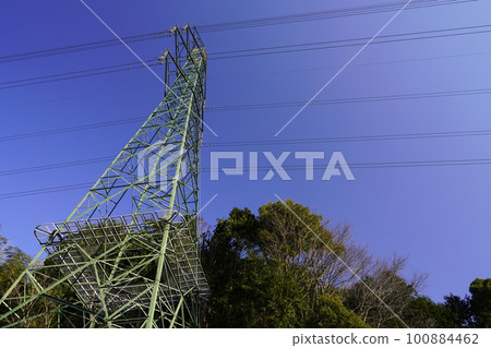 Shooting a landscape with a transmission line tower against a clear blue sky 100884462