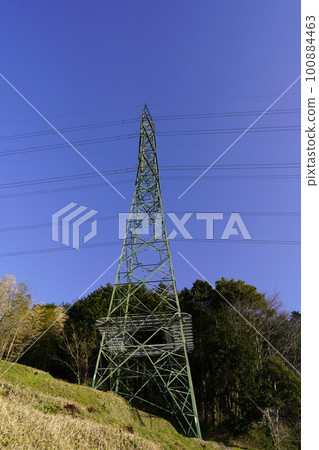 Shooting a landscape with a transmission line tower against a clear blue sky 100884463