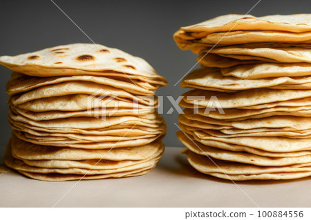 Stack of homemade wheat flour tortillas for making takos on grey table background. Mexican food concept. 100884556