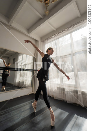 A beautiful Asian ballerina is training in a dance class. Vertical photo. 100885142