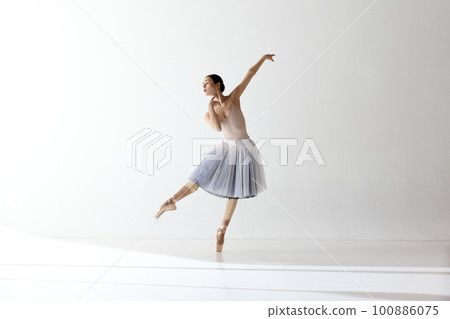 Beautiful woman ballet dancer dancing over white background. Art, theater, skills, aspiration concept 100886075