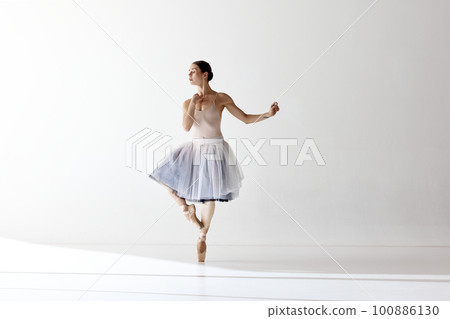 Inspired beautiful ballerina dancing and looking away over white background 100886130