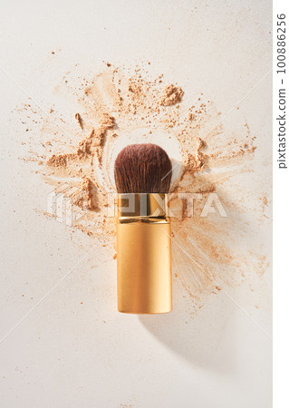 Soft cosmetic brush, with shining sparkling powder on the bristles.The powder is scattered on the table, on a light background with space to copy in the concept of beauty and makeup.High quality photo Soft cosmetic brush, with shining sparkling powder on the bristles.The powder is scattered on the table, on a light background with space to copy in the concept of beauty and makeup.High quality photo 100886256