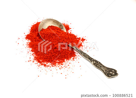 Metal spoon full of red hot chili pepper 100886521