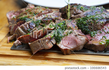 Portion of grilled beef chateaubriand with herbs 100886543