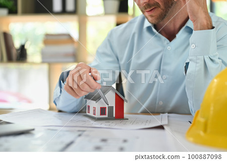 Cropped shot of architect man checking construction plan, working with blueprint at his workstation 100887098
