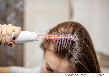 Woman uses darsonval for massage head's skin. Receiving electric darsonval facial massage procedure. Face Beauty Treatment. Darsonval Therapy Using High Frequency D'Arsonval, Skin Care Device . Woman uses darsonval for massage head's skin. Receiving electric darsonval facial massage procedure. Face Beauty Treatment. Darsonval Therapy Using High Frequency D'Arsonval, Skin Care Device . 100889248