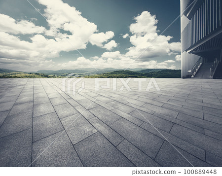 Brick ground square and partial steel structure building with blue sky and white clouds mountain background Brick ground square and partial steel structure building with blue sky and white clouds mountain background 100889448