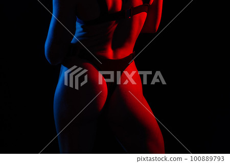Young woman in underwear is in the studio with neon lights. Young woman in underwear is in the studio with neon lights. 100889793