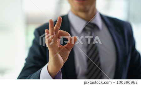 Businessman in suit showing hand gesture ok at work in office closeup Businessman in suit showing hand gesture ok at work in office closeup 100890962