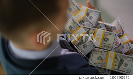 Banker holding in hands lot of packages with money closeup Banker holding in hands lot of packages with money closeup 100890971