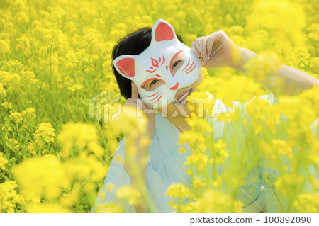 Japanese woman in a beautiful yellow flowers field 100892090