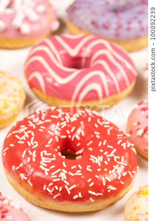 Donuts with red and pink glaze, top view. Lots of donuts, sweet and delicious food Donuts with red and pink glaze, top view. Lots of donuts, sweet and delicious food 100892239