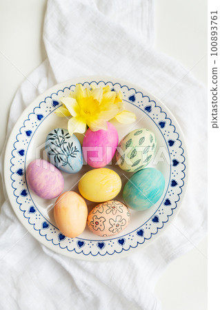 Easter eggs are painted in different colors and patterns on the plate. Top view, Easter celebration concept. 100893761