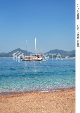 The famous resort island of St. Stephen in the Adriatic Sea, Montenegro. Sea vacation concept, yacht in the sea. The famous resort island of St. Stephen in the Adriatic Sea, Montenegro. Sea vacation concept, yacht in the sea. 100893766