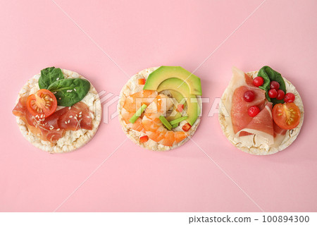 Puffed rice cakes with different toppings on pink background, flat lay Puffed rice cakes with different toppings on pink background, flat lay 100894300