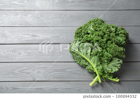 Fresh kale leaves on light grey wooden table, top view. Space for text 100894332